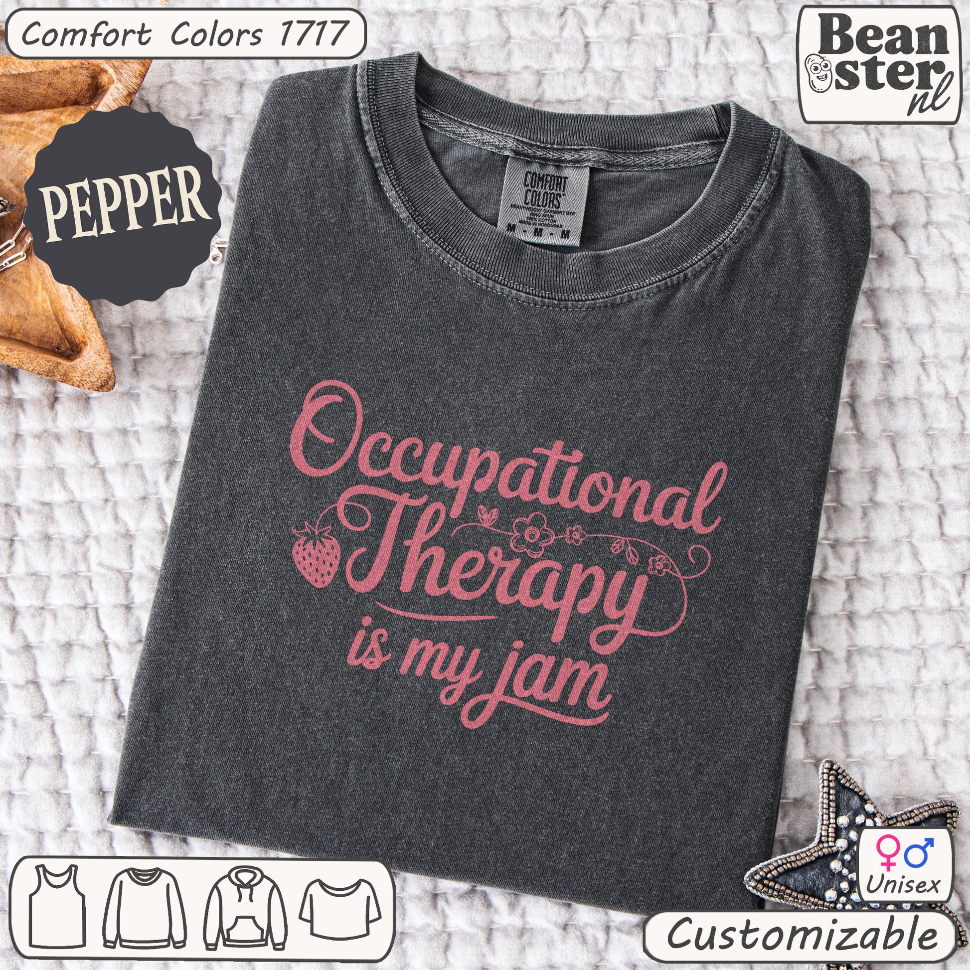 Folded dark gray t-shirt with pink text 'Occupational Therapy is my jam' on a textured surface, featuring Beanster branding.