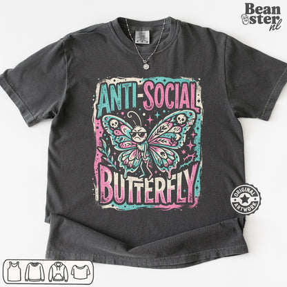 A dark gray graphic t-shirt featuring a distressed print of a butterfly with sunglasses and the text 'ANTI-SOCIAL BUTTERFLY' in pink and teal. The t-shirt is laid flat on a white background with a Beanster.