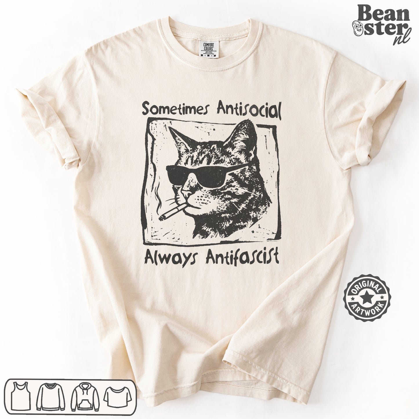 A cream-colored short-sleeve t-shirt with a black graphic print of a cat wearing sunglasses and a cigarette, with the text 'Sometimes Antisocial' above and 'Always Antifascist' below. The t-shirt is laid flat on a white background with a 'Beanster.