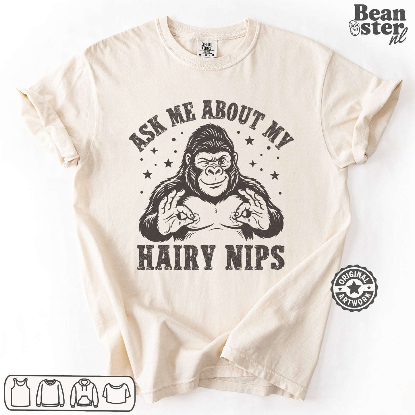 A beige short-sleeve graphic t-shirt laid flat on a white background. The shirt features a black graphic of a gorilla flexing its chest with the text 'ASK ME ABOUT MY HAIRY NIPS' printed around it.