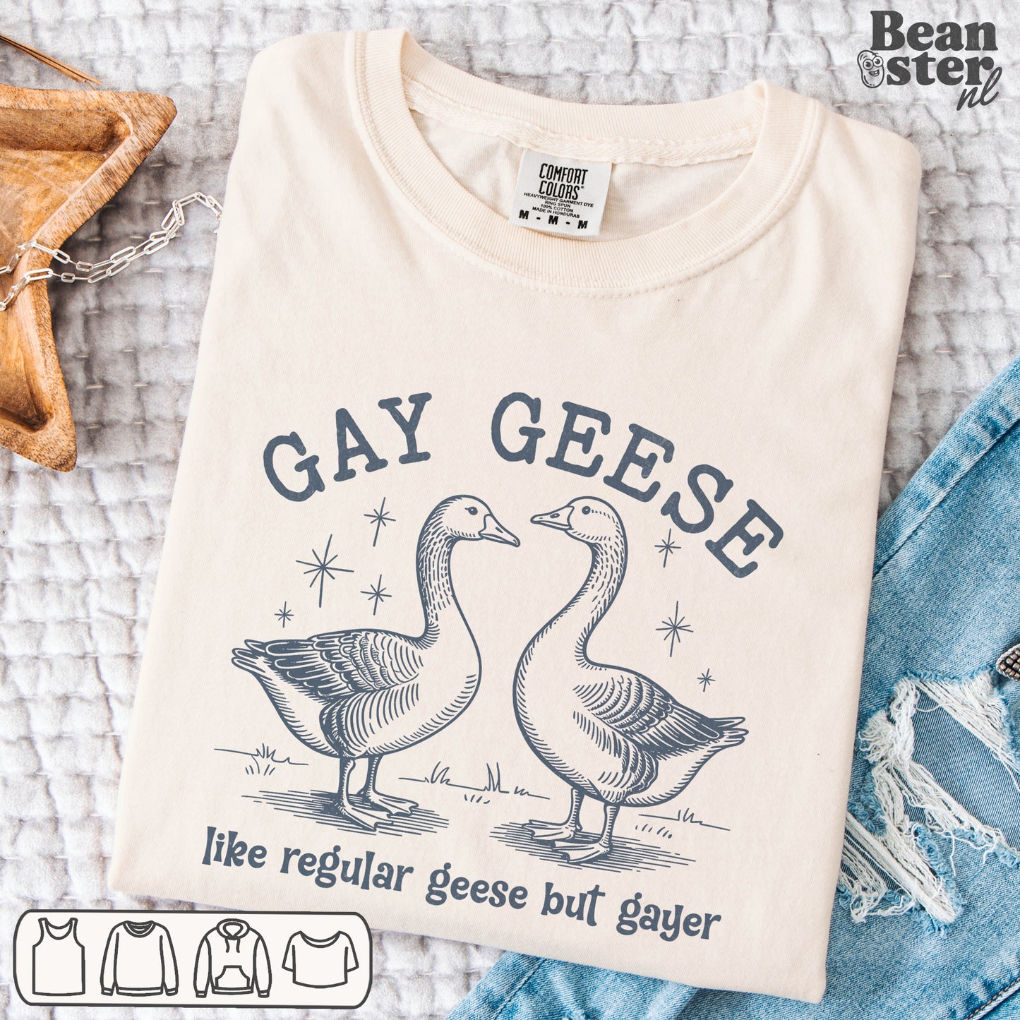 Folded t-shirt with 'Gay Geese' graphic design on a textured surface.