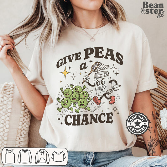 White graphic t-shirt featuring “Give Peas A Chance” text with funny veggie pun peace-inspired original design