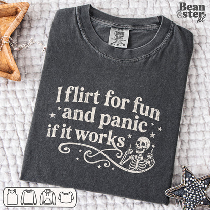 Black graphic tee reading “I Flirt For Fun And Panic When It Works” styled on model in casual streetwear