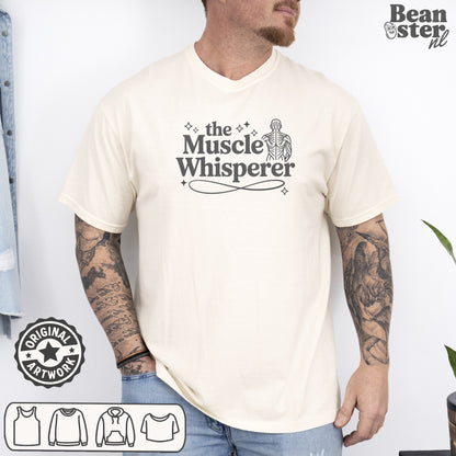 Person wearing a white t-shirt with 'The Muscle Whisperer' design, standing against a plain background.