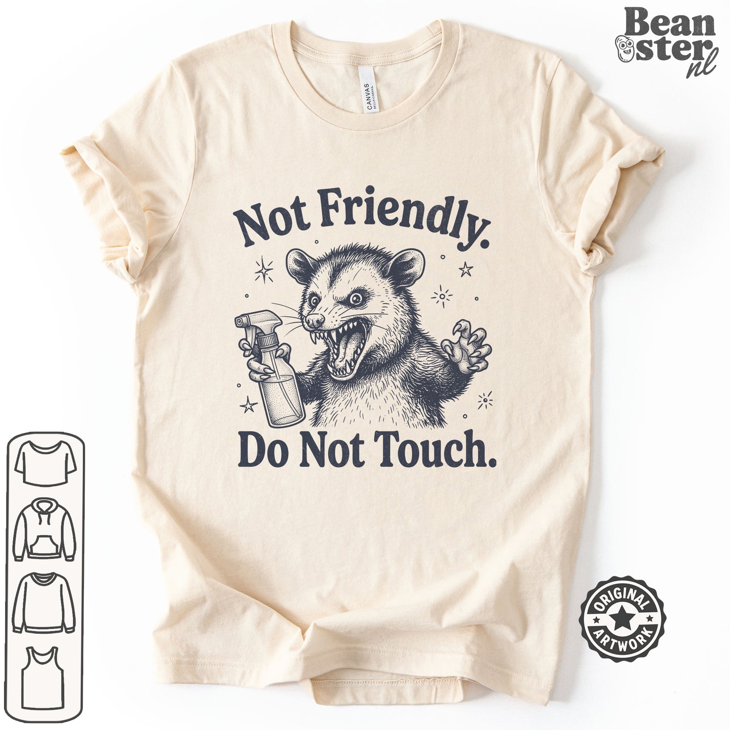 A beige short-sleeve t-shirt with a dark graphic of a mischievous possum holding a spray bottle, accompanied by the text 'Not Friendly. Do Not Touch.