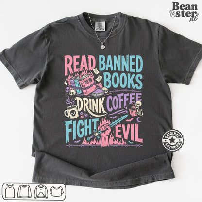 A dark gray graphic t-shirt featuring a colorful design with the text 'READ BANNED BOOKS DRINK COFFEE FIGHT EVIL' and illustrations of a library, coffee cup, skull, and book. The t-shirt is displayed flat against a white background with a 'Beanster.