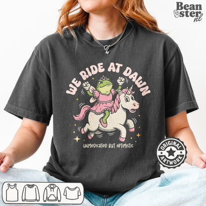 We Ride At Dawn graphic t-shirt original design cowboy fantasy streetwear aesthetic