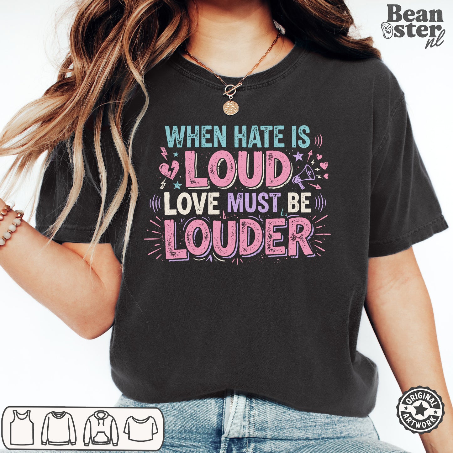 A woman wearing a black graphic t-shirt with the text 'WHEN HATE IS LOUD LOVE MUST BE LOUDER' in pink, purple, and teal lettering. The photo is cropped from the chest down, showing the fit of the shirt, with a 'Beanster.